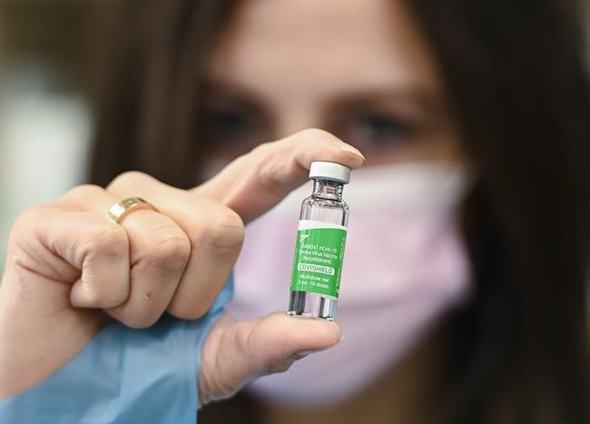 Pharmacist Barbara Violo shows off a vile of the Oxford-AstraZeneca COVID-19 vaccine after providing doses to customers at the Junction Chemist, an independent pharmacy in Toronto, Friday, March 12, 2021. THE CANADIAN PRESS/Nathan Denette