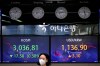 A currency trader walks near screens showing the Korea Composite Stock Price Index (KOSPI), left, and the foreign exchange rate between U.S. dollar and South Korean won at the foreign exchange dealing room in Seoul, South Korea, Monday, March 15, 2021. THE CANADIAN PRESS/AP-Lee Jin-man