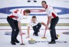 Team Canada skip Brendan Bottcher, centre, makes a shot as lead Karrick Martin, right, and second Brad Thiessen sweep while they play Scotland at the Men's World Curling Championships in Calgary, Alta., Friday, April 2, 2021.THE CANADIAN PRESS/Jeff McIntosh