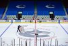 An arena worker removes the net from the ice after the Vancouver Canucks and Calgary Flames NHL hockey game was postponed due to a positive COVID-19 test result, in Vancouver, on Wednesday, March 31, 2021. THE CANADIAN PRESS/Darryl Dyck