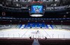 An arena worker removes the net from the ice after the Vancouver Canucks and Calgary Flames NHL hockey game was postponed due to a positive COVID-19 test result, in Vancouver, on Wednesday, March 31, 2021. THE CANADIAN PRESS/Darryl Dyck