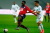 Lille's Jonathan David, left, is challenged by Marseille's Yuto Nagatomo during the French League One soccer match between Lille and Marseille at the Stade Pierre Mauroy stadium in Villeneuve-d'Ascq, France, Wednesday, March 3, 2021. David will be out for several weeks after rupturing the lateral ligament in his right ankle playing for Lille. THE CANADIAN PRESS/AP/Michel Spingler