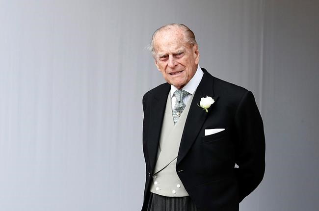 In this Friday, Oct. 12, 2018 file photo, Britain's Prince Philip waits for the bridal procession following the wedding of Princess Eugenie of York and Jack Brooksbank at St George's Chapel in Windsor Castle, England. Buckingham Palace officials say Prince Philip, the husband of Queen Elizabeth II, has died, it was announced on Friday, April 9, 2021. THE CANADIAN PRESS/AP/Alastair Grant