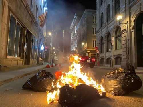 People take part in an anti-curfew protest in Montreal on Sunday April 11, 2021. Hundreds of people gathered in Old Montreal tonight in defiance of a new 8 p.m. curfew. THE CANADIAN PRESS/Giuseppe Valiante