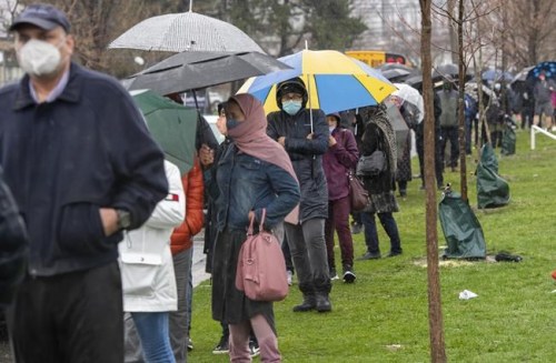 People line up in the rain for a COVID-19 vaccine at a pop-up clinic at the Masjid Darus Salaam in the Thorncliffe Park neighbourhood in Toronto on Sunday, April 11, 2021. THE CANADIAN PRESS/Frank Gunn