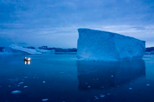 In this Aug. 15, 2019, photo, a boat navigates at night next to large icebergs in eastern Greenland. Greenland's ice has been melting for more than 20 years. THE CANADIAN PRESS/AP-Felipe Dana