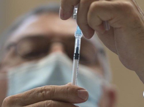 Jose Marchand prepares Pfizer COVID-19 vaccination doses at a mobile clinic for members of First Nations and their partners, in Montreal, Friday, April 30, 2021. The National Advisory Committee on Immunization is coming under fire after contradicting the advice Canadians have been receiving for weeks to take the first vaccine against COVID-19 that they're offered. THE CANADIAN PRESS/Ryan Remiorz