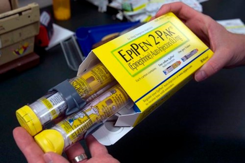 In this July 8, 2016, file photo, a pharmacist holds a package of EpiPens epinephrine auto-injector, a Mylan product, in Sacramento, Calif.&nbsp; THE CANADIAN PRESS/AP-Rich Pedroncelli