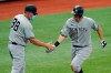 FILE- In this April 9, 2021, file photo, New York Yankees' DJ LeMahieu celebrates with third base coach Phil Nevin (88) after his home run off Tampa Bay Rays pitcher Hunter Strickland during the eighth inning of a baseball game in St. Petersburg, Fla. The Yankees announced Tuesday, May 11, 2021, that Nevin, who is fully vaccinated, has tested positive for the coronavirus. He is currently under quarantine protocol in Tampa. Under Major League Baseball’s guidance and advice, and with its assistance, additional testing and contact tracing are ongoing. (AP Photo/Chris O'Meara, File)