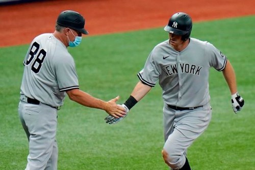FILE- In this April 9, 2021, file photo, New York Yankees' DJ LeMahieu celebrates with third base coach Phil Nevin (88) after his home run off Tampa Bay Rays pitcher Hunter Strickland during the eighth inning of a baseball game in St. Petersburg, Fla. The Yankees announced Tuesday, May 11, 2021, that Nevin, who is fully vaccinated, has tested positive for the coronavirus. He is currently under quarantine protocol in Tampa. Under Major League Baseball’s guidance and advice, and with its assistance, additional testing and contact tracing are ongoing. (AP Photo/Chris O'Meara, File)