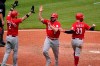 Cincinnati Reds' Mike Moustakas (9) is greeted by Nick Castellanos (2) and Jesse Winker after they all scored on a double by Eugenio Suarez off Pittsburgh Pirates relief pitcher Duane Underwood Jr. during the tenth inning of a baseball game in Pittsburgh, Wednesday, May 12, 2021.(AP Photo/Gene J. Puskar)