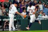 Houston Astros' Jose Altuve (27) is congratulated by first base coach Omar Lopez (22) after hitting a home run against the Los Angeles Angels during the first inning of a baseball game Wednesday, May 12, 2021, in Houston. (AP Photo/David J. Phillip)