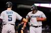 Miami Marlins' Jesus Aguilar, right, smiles as he celebrates with Jon Berti after scoring against the Arizona Diamondbacks during the seventh inning of a baseball game Thursday, May 13, 2021, in Phoenix. (AP Photo/Ross D. Franklin)