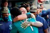 Seattle Mariners' Jarred Kelenic, center right, is embraced by Kyle Lewis (1) after hitting a two-run home run against the Cleveland Indians in the third inning of a baseball game Friday, May 14, 2021, in Seattle. (AP Photo/Elaine Thompson)