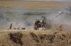 An Israeli artillery unit fires toward targets in the Gaza Strip, at the Israel-Gaza border, Saturday, May 15, 2021. (AP Photo/Ariel Schalit)