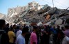 People gather at in front of a building housing AP office and other media in Gaza City that was destroyed after Israeli warplanes demolished it, Saturday, May 15, 2021. The airstrike Saturday came roughly an hour after the Israeli military ordered people to evacuate the building. There was no immediate explanation for why the building was targeted. (AP Photo/Hatem Moussa)