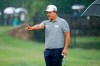 Kyoung-Hoon Lee of South Korea stands in a pouring rain as he lines up his putt on the ninth green during the final round of the AT&T Byron Nelson golf tournament in McKinney, Texas, Sunday, May 16, 2021. (AP Photo/Ray Carlin)