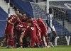 Liverpool's goalkeeper Alisson celebrates with teammates after scoring his side's second goal during the English Premier League soccer match between West Bromwich Albion and Liverpool at the Hawthorns stadium in West Bromwich, England, Sunday, May 16, 2021. (AP Photo/Rui Vieira, Pool)