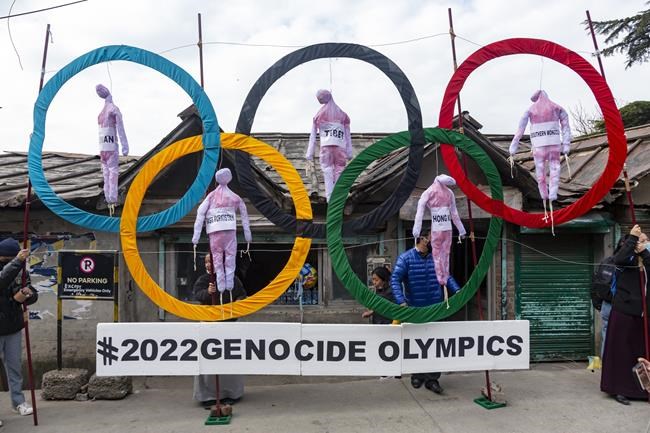 FILE - In this Feb. 3, 2021, file photo, exile Tibetans use the Olympic Rings as a prop as they hold a street protest against the holding of the 2022 Beijing Winter Olympics, in Dharmsala, India. Groups alleging human-rights abuses in China are calling for a full boycott of the Beijing Olympics, which is sure to ratchet up pressure on the International Olympic Committee, athletes, sponsors, and sports federations. A coalition of activists representing Uyghurs, Tibetans, residents of Hong Kong and others, issued a statement Monday, May 17, 2021 calling for the “full boycott,” eschewing lesser measures like “diplomatic boycotts