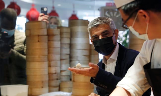 Mayor of London Sadiq Khan, second right attempts to prepare dumplings with head chef Ling Bing, during a visit to Dumplings Legend in China Town central London, Monday, May 17, 2021. Pubs and restaurants across much of the U.K. are opening for indoor service for the first time since early January even as the prime minister urged people to be cautious amid the spread of a more contagious COVID-19 variant. (AP Photo/Alastair Grant)