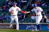 Chicago Cubs' Willson Contreras, left, is greeted by Javier Baez, right, after scoring against the Washington Nationals during the first inning of a baseball game, Monday, May, 17, 2021, in Chicago. (AP Photo/David Banks)