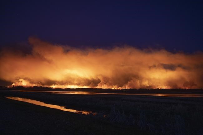 A forest fire burns late into the evening northeast of Prince Albert, Sask., on Monday, May 17, 2021. THE CANADIAN PRESS/Kayle Neis