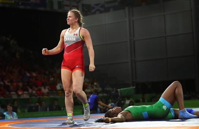 Canada's Erica Wiebe, left, celebrates after defeating Nigeria's Blessing Onyebuchi, right on the ground, to win Gold medal in women's FS 76Kg wrestling at the Commonwealth Games on Gold Coast, Australia, Thursday, April 12, 2018. THE CANADIAN PRESS/AP-Manish Swarup