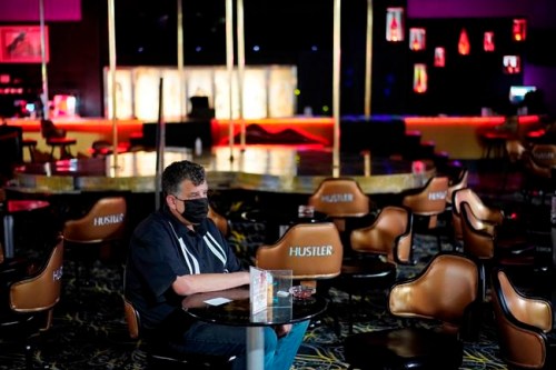 Jeff Cantrell waits at Larry Flint's Hustler Club strip club after getting his second dose of coronavirus vaccine Friday, May 21, 2021, in Las Vegas. Las Vegas officials held a pop-up vaccine clinic at the strip club (AP Photo/John Locher)