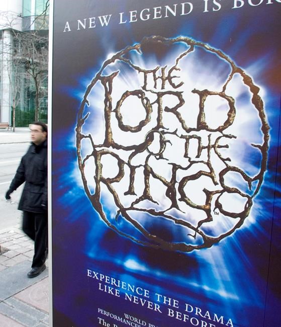 A man walks past a sign advertising the theatrical production of the Lord of the Rings in downtown Toronto Wednesday Feb. 8, 2006. THE CANADIAN PRESS/Adrian Wyld
