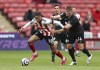 Sheffield United's Daniel Jebbison, left, and Burnley's Jimmy Dunne battle for the ball during the English Premier League soccer match at Bramall Lane, Sheffield, England, Sunday May 23, 2021. (Jan Kruger/Pool via AP)