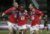 Lille's Burak Yilmaz, left, celebrates with Renato Sanches, center, and Yusuf Yazici after scoring the second goal from the penalty spot during the French League One soccer match between Angers and Lille at the Raymond Kopa Stadium in Angers, France, Sunday May 23, 2021. (AP Photo/Lewis Joly)