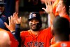 Houston Astros' Jose Altuve is greeted in the dugout by teammates after scoring against the Texas Rangers during the eighth inning of a baseball game in Arlington, Texas, Sunday, May 23, 2021. (AP Photo/Ray Carlin)