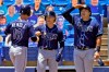 Tampa Bay Rays' Joey Wendle, left, shakes hands with Taylor Walls, center, as Ji-Man Choi pretends to see how far the ball went after Wendle hit a grand slam off Toronto Blue Jays starting pitcher Trent Thornton during the first inning of a baseball game Monday, May 24, 2021, in Dunedin, Fla. (AP Photo/Chris O'Meara)