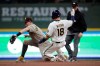 Milwaukee Brewers' Keston Hiura (18) slides safely into second base past the tag of San Diego Padres' Jake Cronenworth, left, during the fourth inning of a baseball game Monday, May 24, 2021, in Milwaukee. Hiura advanced on a wild pitch. (AP Photo/Aaron Gash)