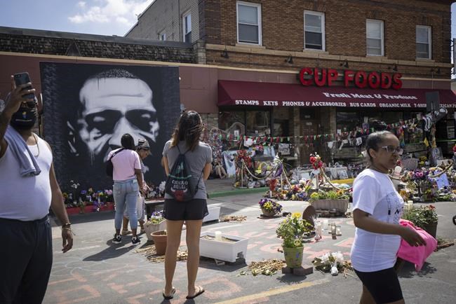 People walk through George Floyd Square after shots were fired on the one year anniversary of George Floyd's death on Tuesday, May 25, 2021, in Minneapolis. The intersection where George Floyd died was disrupted by gunfire Tuesday, just hours before it was to be the site of a family-friendly street festival marking the anniversary of his death at the hands of police.(AP Photo/Christian Monterrosa)