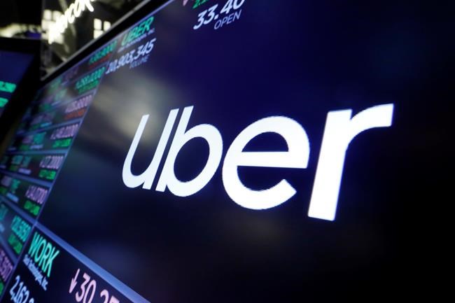 FILE - In this Aug. 16, 2019 file photo, the logo for Uber appears above a trading post on the floor of the New York Stock Exchange. Uber is formally recognizing a major British trade union so it can represent drivers, in a breakthrough for labor campaigners seeking fairer working conditions from the ride-hailing giant. The San Francisco-based company said Wednesday, May 26, 2021 that it signed a collective bargaining agreement with the GMB trade union, one of the U.K.'s biggest. (AP Photo/Richard Drew, file)