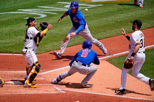 Pittsburgh Pirates first baseman Will Craig, right, tosses the ball to catcher Michael Perez, left, after Chicago Cubs' Javier Baez (9) hit a fielder's choice third to first and was caught in a rundown between home and first during the third inning of a baseball game in Pittsburgh, Thursday, May 27, 2021. Cub's Willson Contreras, top center, scores on the play and Báez reached second on an errant throw by Pirates' catcher Perez. (AP Photo/Gene J. Puskar)