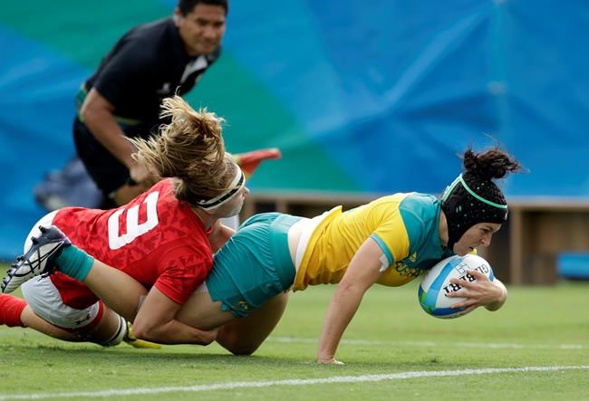 FILE - In this Aug. 8, 2016, file photo, Australia's Emilee Cherry, right, scores a try as Canada's Karen Paquin, defends during the women's rugby sevens semi final match at the Summer Olympics in Rio de Janeiro, Brazil. Cherry, the former women's sevens player of the year who gave birth to a daughter in 2019 announced Friday, May 28, 2021, that she's retiring and won't be in the Australian team when the Tokyo Olympic Games begin on July 23. (AP Photo/Themba Hadebe, File)