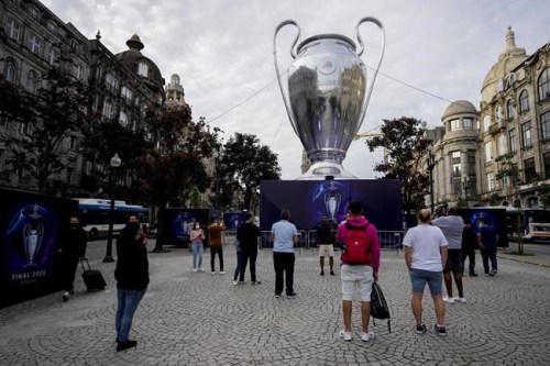 People gather next to a giant replica of the UEFA Champions League trophy in Porto, Portugal, Thursday, May 27, 2021. Manchester City will play against Chelsea in the Champions League final on Saturday. (AP Photo/Manu Fernandez)