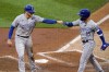 Kansas City Royals' Hunter Dozier (17) gets a fist bump from Whit Merrifield after scoring on a double by Michael Taylor off Minnesota Twins relief pitcher Randy Dobnak during the fifth inning of a baseball game Friday, May 28, 2021, in Minneapolis. (AP Photo/Jim Mone)