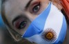 A woman wears a face mask with the colors of the Argentine flag colors during a protest against how the government of President Alberto Fernandez is handling of the new coronavirus pandemic crisis, in Buenos Aires, Argentina, Tuesday, May 25, 2021. (AP Photo/Marcos Brindicci)