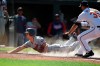 Minnesota Twins' Rob Refsnyder, left, slides across the plate as Baltimore Orioles pitcher Adam Plutko covers in the 10th inning of a baseball game Monday, May 31, 2021, in Baltimore. Refsnyder was safe, scoring the go-ahead run on a wild pitch. (AP Photo/Gail Burton)