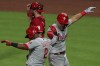 Philadelphia Phillies' Jean Segura, left, celebrates the two-run home run by Rhys Hoskins, right, during the sixth inning of a baseball game against the Cincinnati Reds in Cincinnati, Tuesday, June 1, 2021. (AP Photo/Aaron Doster)