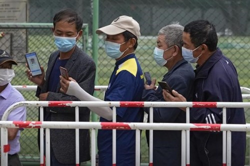 Residents wearing face masks to help curb the spread of the coronavirus look at their smartphones showing health code as they line up to receive the Sinopharm COVID-19 vaccine at a vaccination center in Central Business District in Beijing on Wednesday, June 2, 2021. After a slow start, China is now doing what virtually no other country in the world can: harnessing the power and all-encompassing reach of its one-party system and a maturing domestic vaccine industry to administer shots at a staggering pace. (AP Photo/Andy Wong)