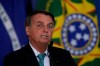 Brazil's President Jair Bolsonaro confirms his country to host the 2021 Copa America soccer tournament, during a ceremony of the state bank sponsoring Brazilian athletics, at the Planalto presidential palace, in Brasilia, Brazil, Tuesday, June 1, 2021. (AP Photo/Eraldo Peres)
