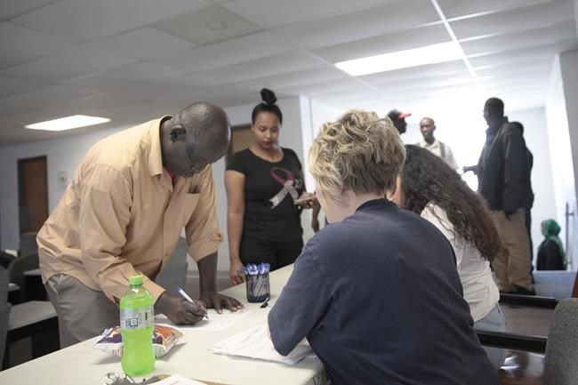 Employees of a Smithfield pork processing plant register to vote Thursday, June 3, 2021, on a contract offer from the company at the union's office in Sioux Falls, S.D. The union voted overwhelmingly against it, escalating labor negotiations. (AP Photo/Stephen Groves)