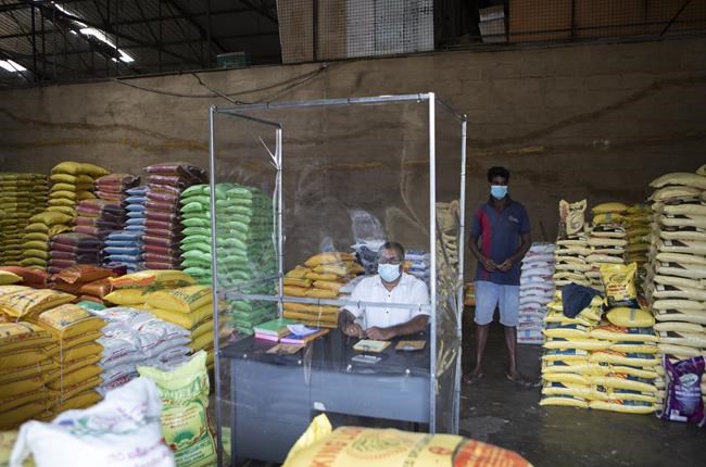 A Sri Lankan trader waits for customers adhering to health guidelines given by the authorities to curb the spread of coronavirus at a wholesale market in Welisara, outskirts of Colombo, Sri Lanka, Monday, May 31, 2021. (AP Photo/Eranga Jayawarden)