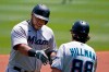Miami Marlins' Jesus Aguilar, left, rounds third to greetings from third base coach Trey Hillman, right, after hitting a solo home run off Pittsburgh Pirates starting pitcher Chad Kuhl during the first inning of a baseball game in Pittsburgh, Sunday, June 6, 2021. (AP Photo/Gene J. Puskar)