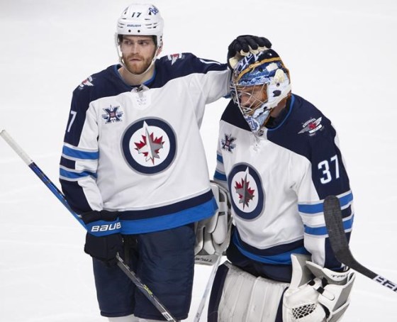 Winnipeg Jets goaltender Connor Hellebuyck (37) gets a pat on the head from teammate Adam Lowry (17) after their overtime NHL Stanley Cup playoff hockey loss to the Montreal Canadiens, in Montreal, Monday, June 7, 2021. THE CANADIAN PRESS/Ryan Remiorz