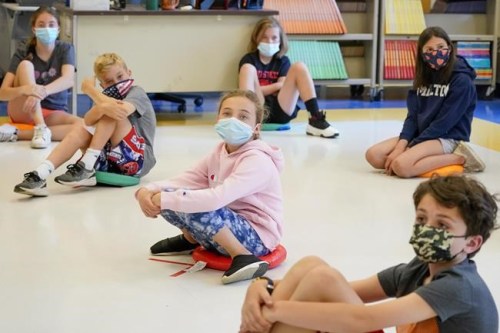 FILE - In this May 18, 2021 file photo, fifth graders wear face masks are seated at proper social distancing spacing during a music class at the Milton Elementary School in Rye, N.Y. As more children go back to the physical classroom, families are expected to spend robustly on a wide range of items, particularly trendy clothing for the critical back-to-school season, according to one key spending measure. (AP Photo/Mary Altaffer, File)